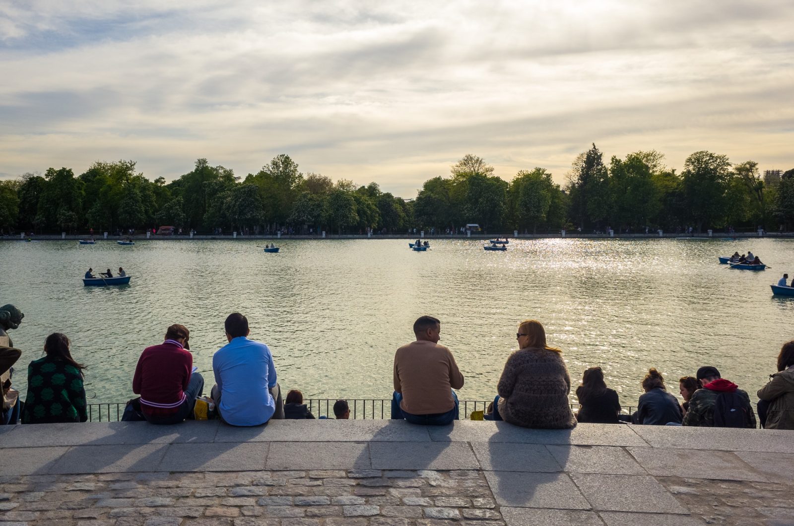 People sitting bellow the monument of Alfonso XII